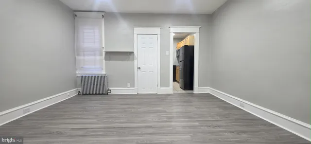 an empty room with wooden floor and closet