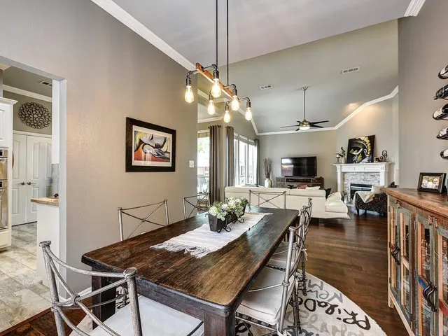 a view of a dining room with furniture a rug and wooden floor