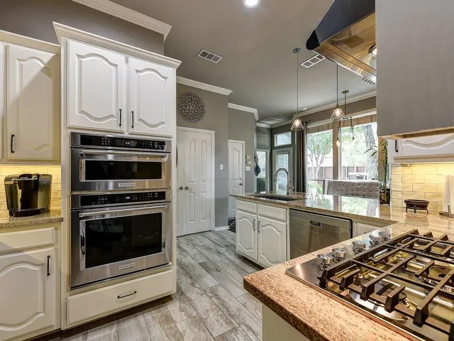 a kitchen with stainless steel appliances granite countertop a stove and a microwave