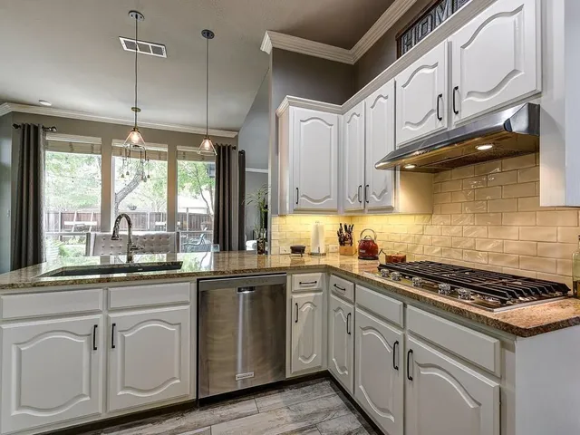 a kitchen with white cabinets and white appliances