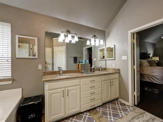 a spacious bathroom with a granite countertop sink a mirror and a