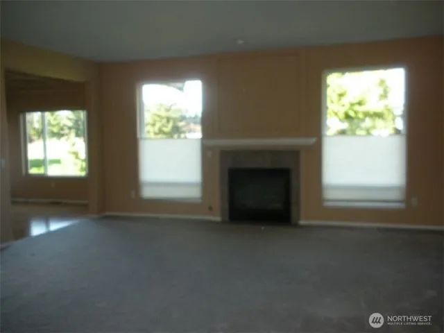 a view of an empty room with a fireplace and a window