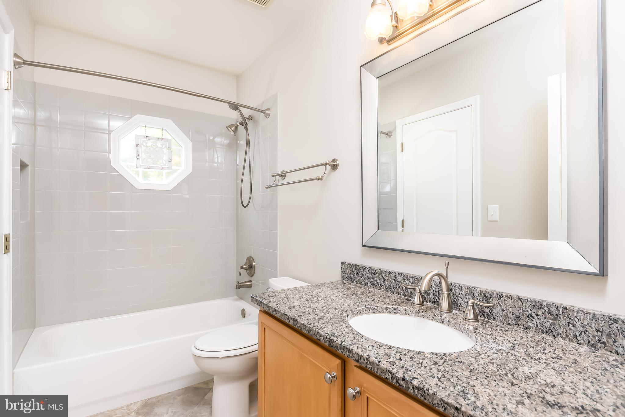 43268 Hillhead Place Leesburg, VA 20176 - Photo 32 of 53 a bathroom with a granite countertop sink toilet mirror and shower