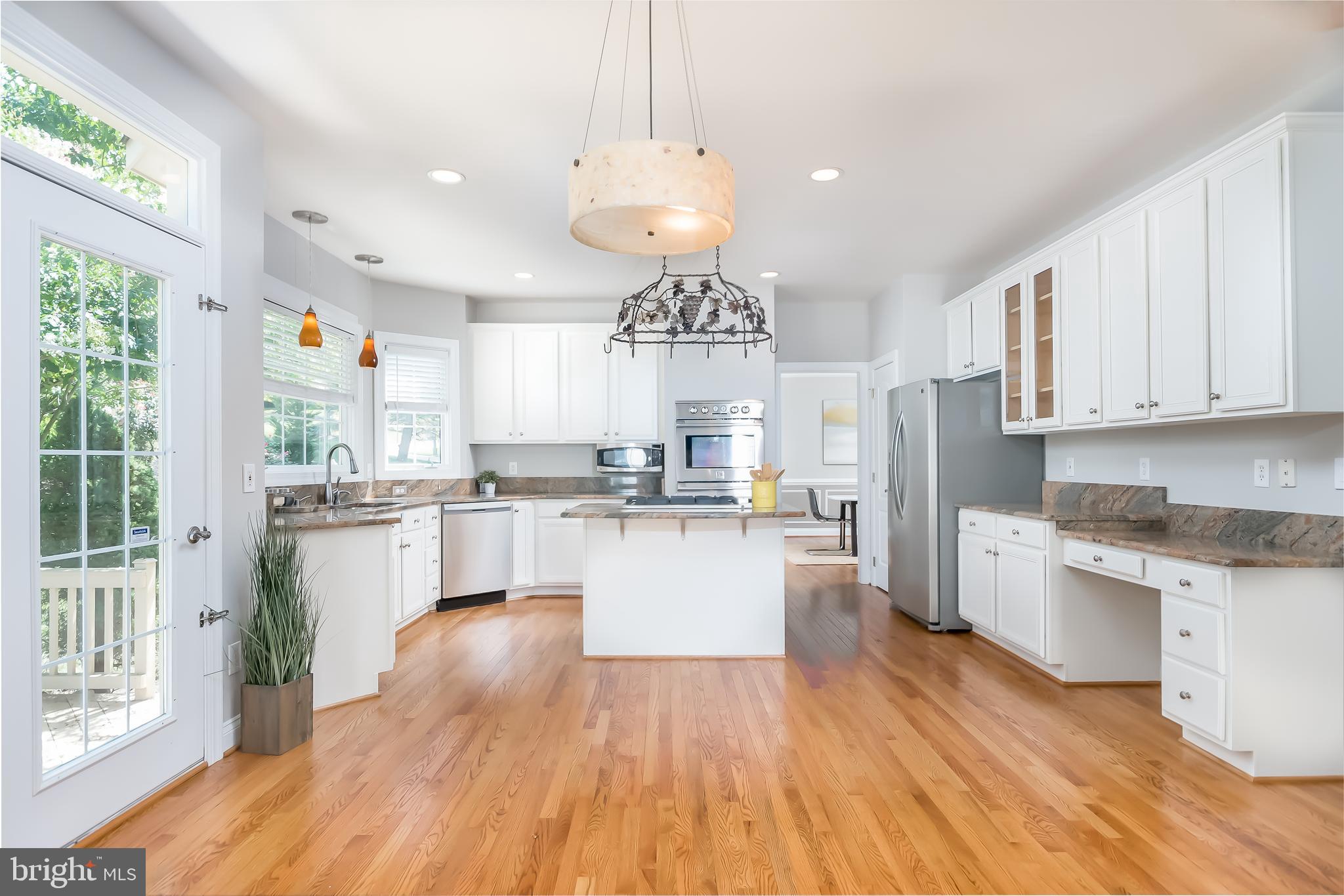 43268 Hillhead Place Leesburg, VA 20176 - Photo 9 of 53 a kitchen with stainless steel appliances granite countertop a refrigerator a stove top oven a sink dishwasher and white cabinets with wooden floor