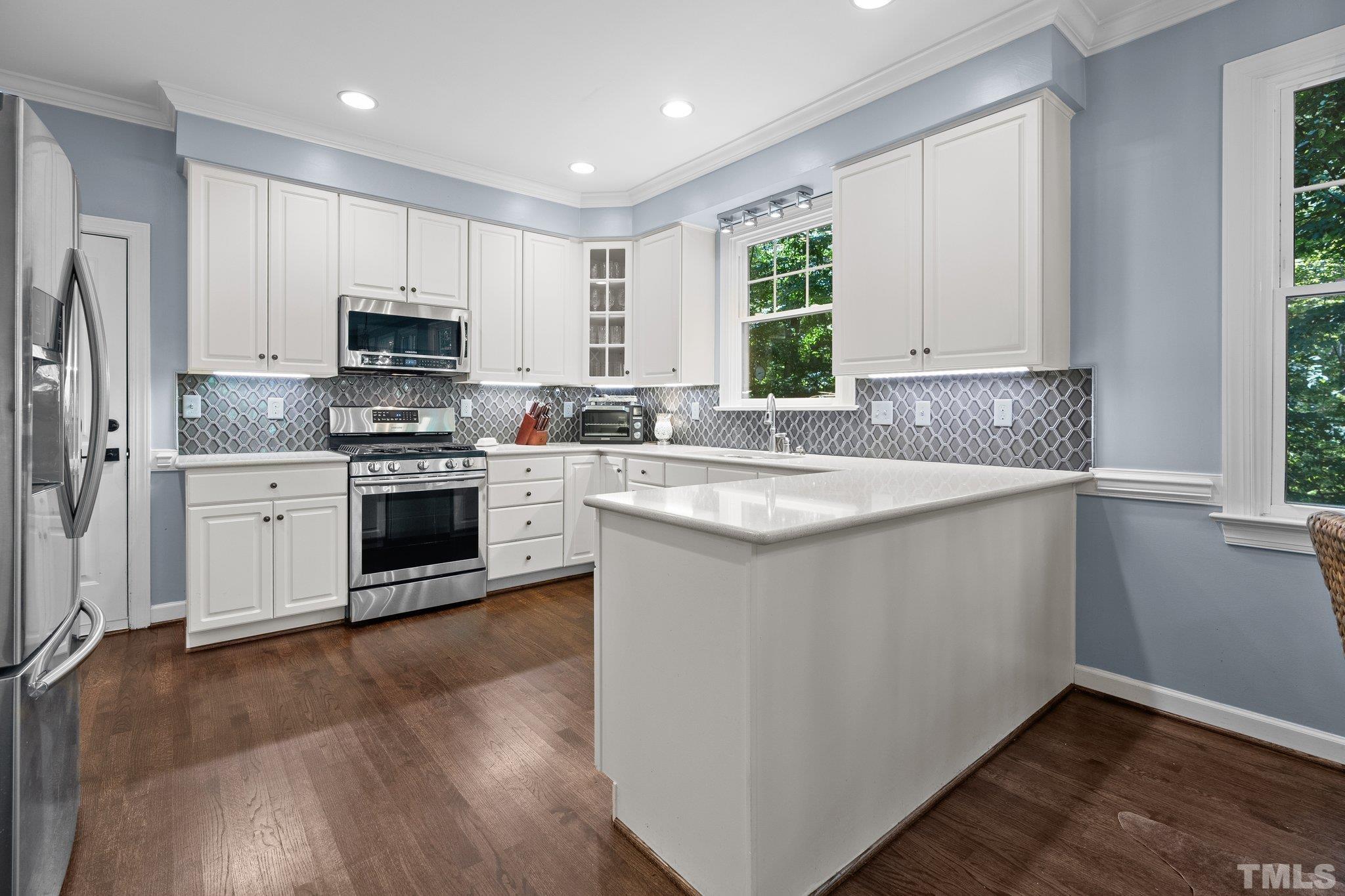 9 Montcrest Drive Durham, NC 27713 - Photo 20 of 43 a kitchen with stainless steel appliances granite countertop a stove a sink dishwasher a refrigerator and a microwave oven with wooden floor