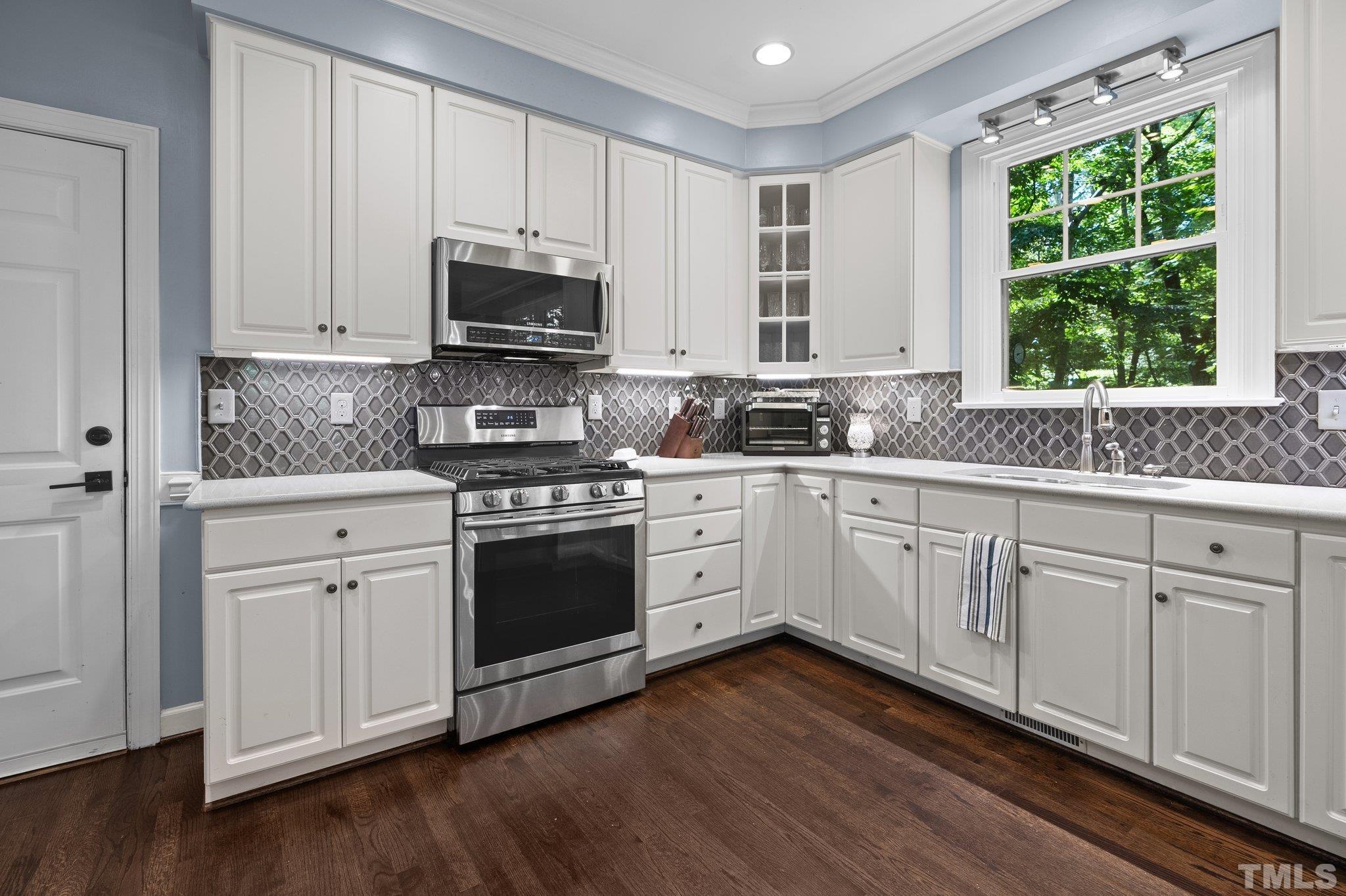 9 Montcrest Drive Durham, NC 27713 - Photo 21 of 43 a kitchen with stainless steel appliances white cabinets granite and wooden floors