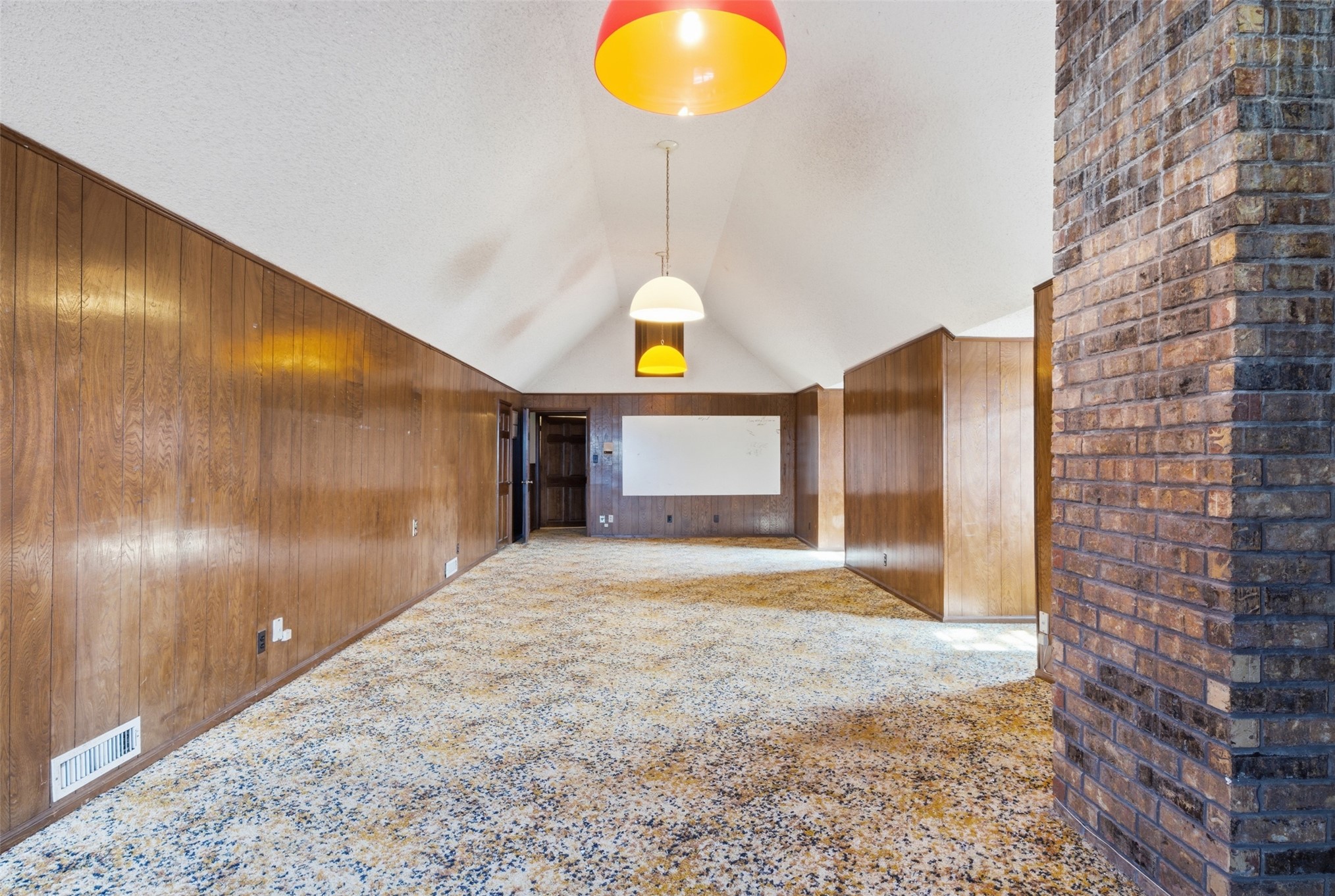 17875 East 589 Road Inola, OK 74036 - Photo 61 of 73 Vaulted ceiling, exposed brick column, wood paneling, recessed lighting, and patterned carpeting