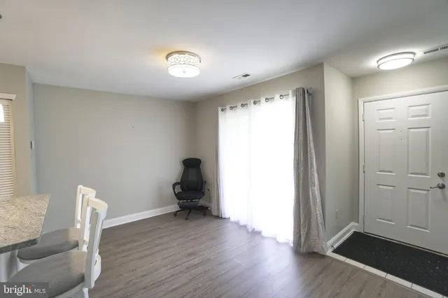 a view of room with wooden floor lounge chair and windows