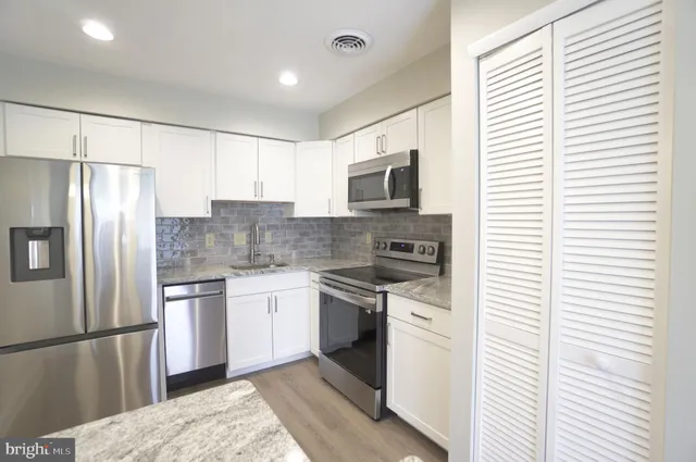 a kitchen with a refrigerator stove and sink