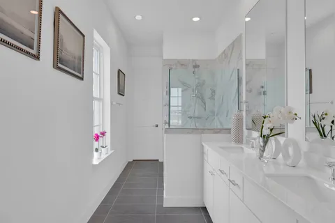 a bathroom with a granite countertop sink a mirror and a shower