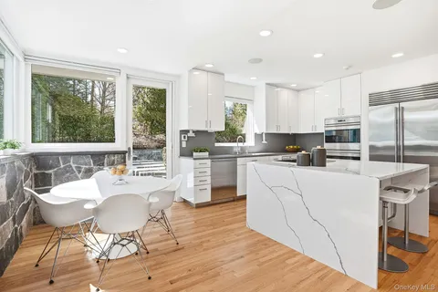 a kitchen with kitchen island wooden floors and stainless steel appliances
