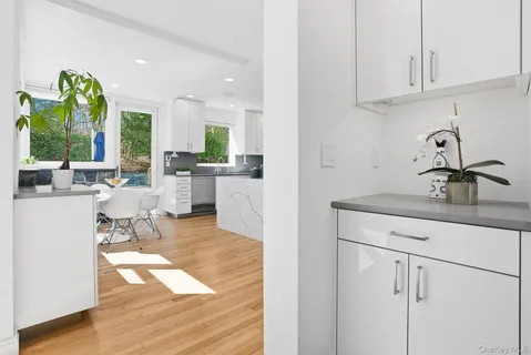 a living room with stainless steel appliances granite countertop furniture and a wooden floor