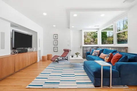 a living room with furniture a flat screen tv and a rug