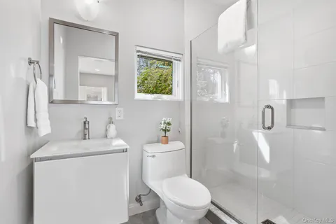 a bathroom with a sink a toilet and shower