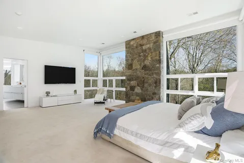 a spacious bedroom with a bed and a flat screen tv