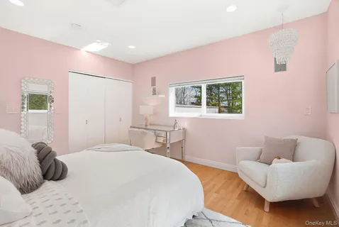 a bedroom with a bed couches chair and a potted plant