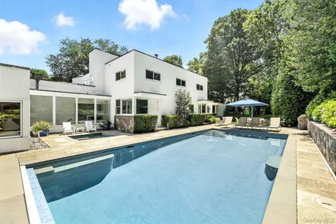a front view of a house with swimming pool and sitting area