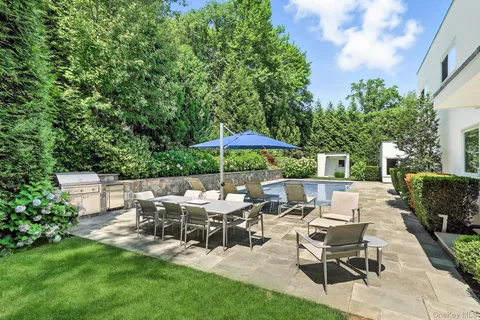 a view of a patio with table and chairs under an umbrella