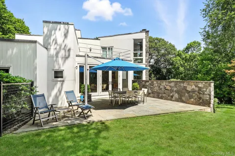 a view of a chair and table in backyard of the house