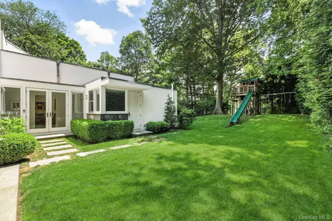 a view of a house with backyard and a tree