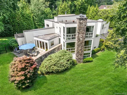 a view of a house with a big yard and large trees
