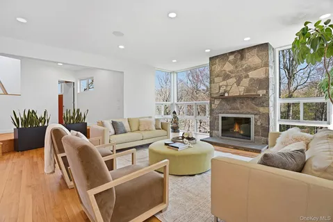 a living room with furniture fireplace and a large window