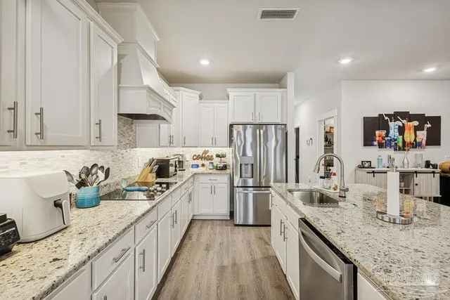 a kitchen with stainless steel appliances granite countertop a sink stove and refrigerator
