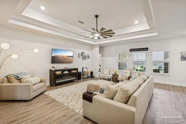 a living room with furniture a ceiling fan and a rug