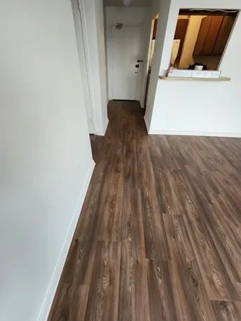 a view of a hallway with wooden floor and entryway