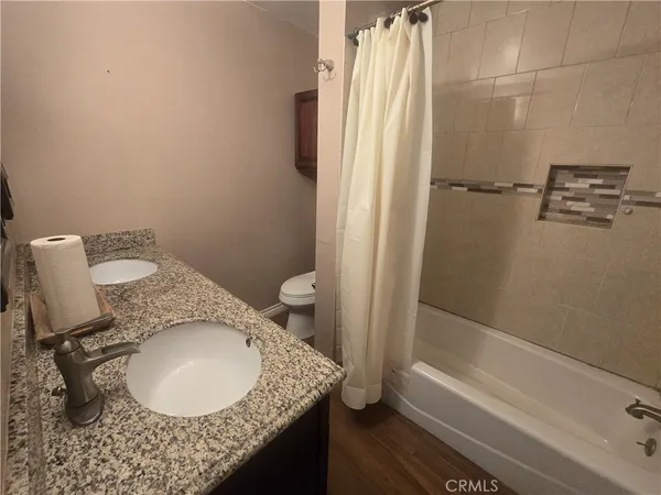 a bathroom with a granite countertop sink toilet and shower