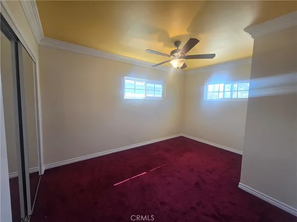 an empty room with a window and a ceiling fan