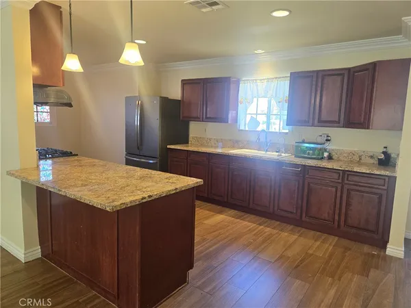 a kitchen with kitchen island granite countertop wooden cabinets a sink and dishwasher