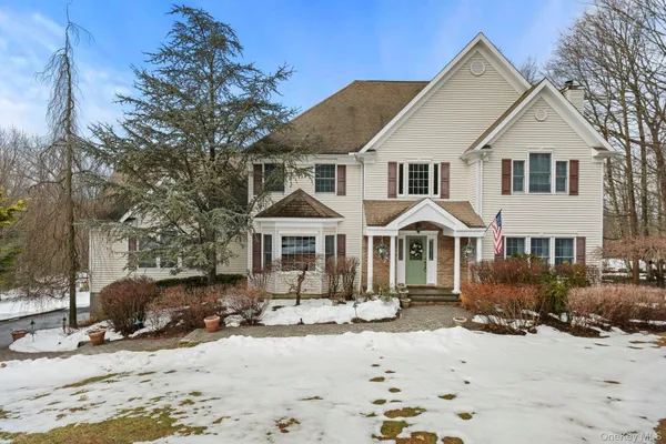 a front view of a house with a yard covered in snow