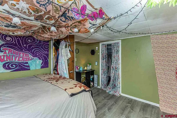 a bed room with a bed a couch and a painting on the wall