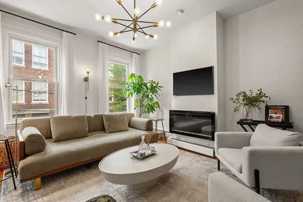 a living room with furniture a fireplace and a flat screen tv