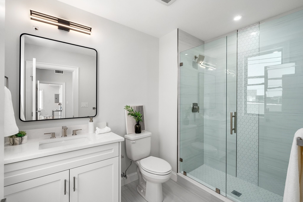 523 2nd Street, Unit 403 Everett, MA 02149 - Photo 7 of 10 a bathroom with a toilet sink shower and mirror