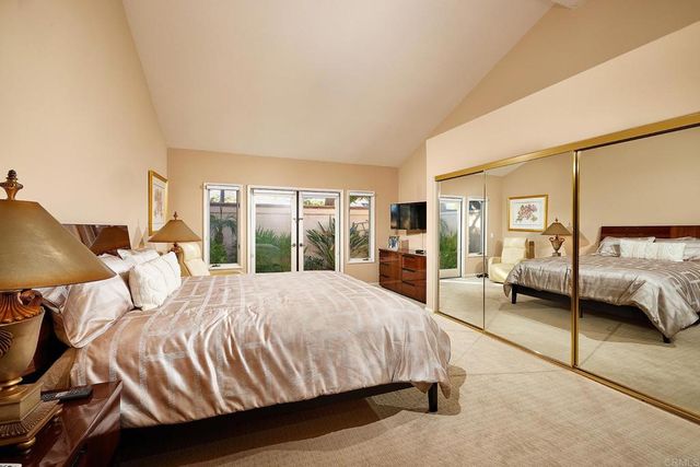 a view of a white house with a small yard and palm trees