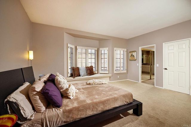 a view of a house with a yard and palm trees