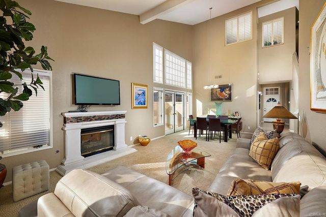 a living room with fireplace furniture and a large window