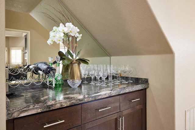 a bathroom with a granite countertop sink a mirror a bathtub and shower