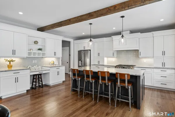 a large kitchen with cabinets a sink a center island and stainless steel appliances