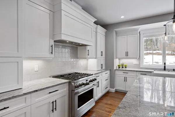 a kitchen with granite countertop white cabinets and appliances