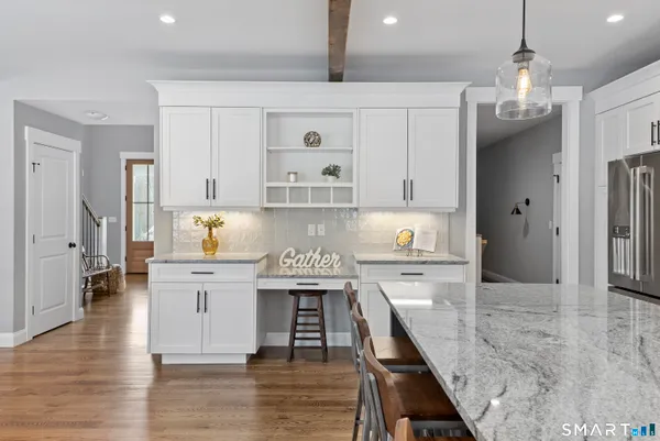 a kitchen with stainless steel appliances granite countertop a lot of counter space and wooden floors