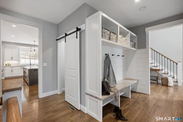 a view of front door with entryway and wooden floor