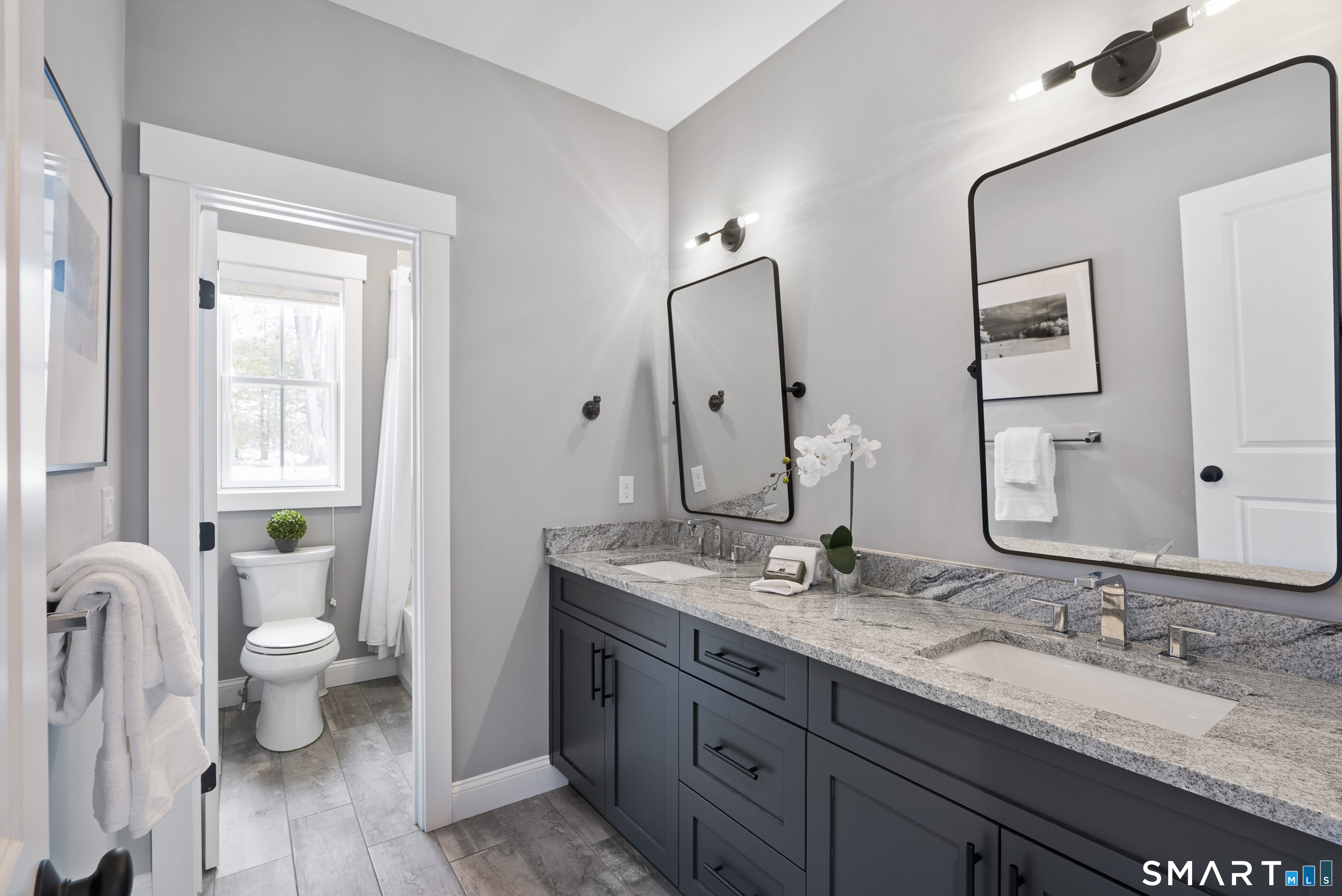 8 Gateshead Way Farmington, CT 06085 - Photo 26 of 39 a bathroom with a granite countertop toilet a double vanity sink a mirror and a window