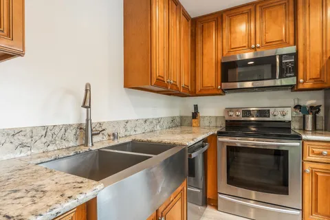 a kitchen with stainless steel appliances granite countertop a sink a stove and microwave