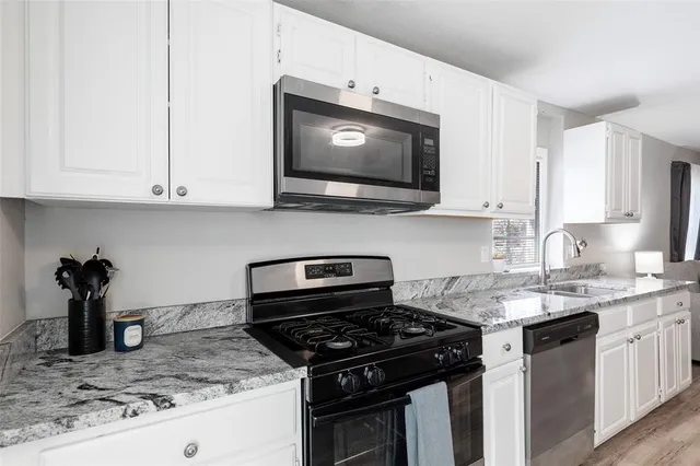 a kitchen with stainless steel appliances granite countertop a sink stove and microwave