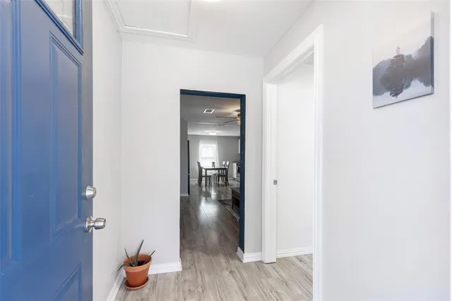a view of a hallway and wooden floor and a bathroom