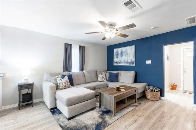 a living room with furniture and a ceiling fan