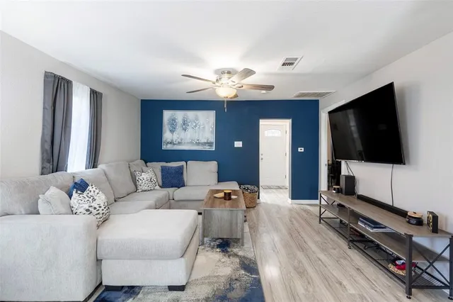 a living room with furniture a flat screen tv and a window